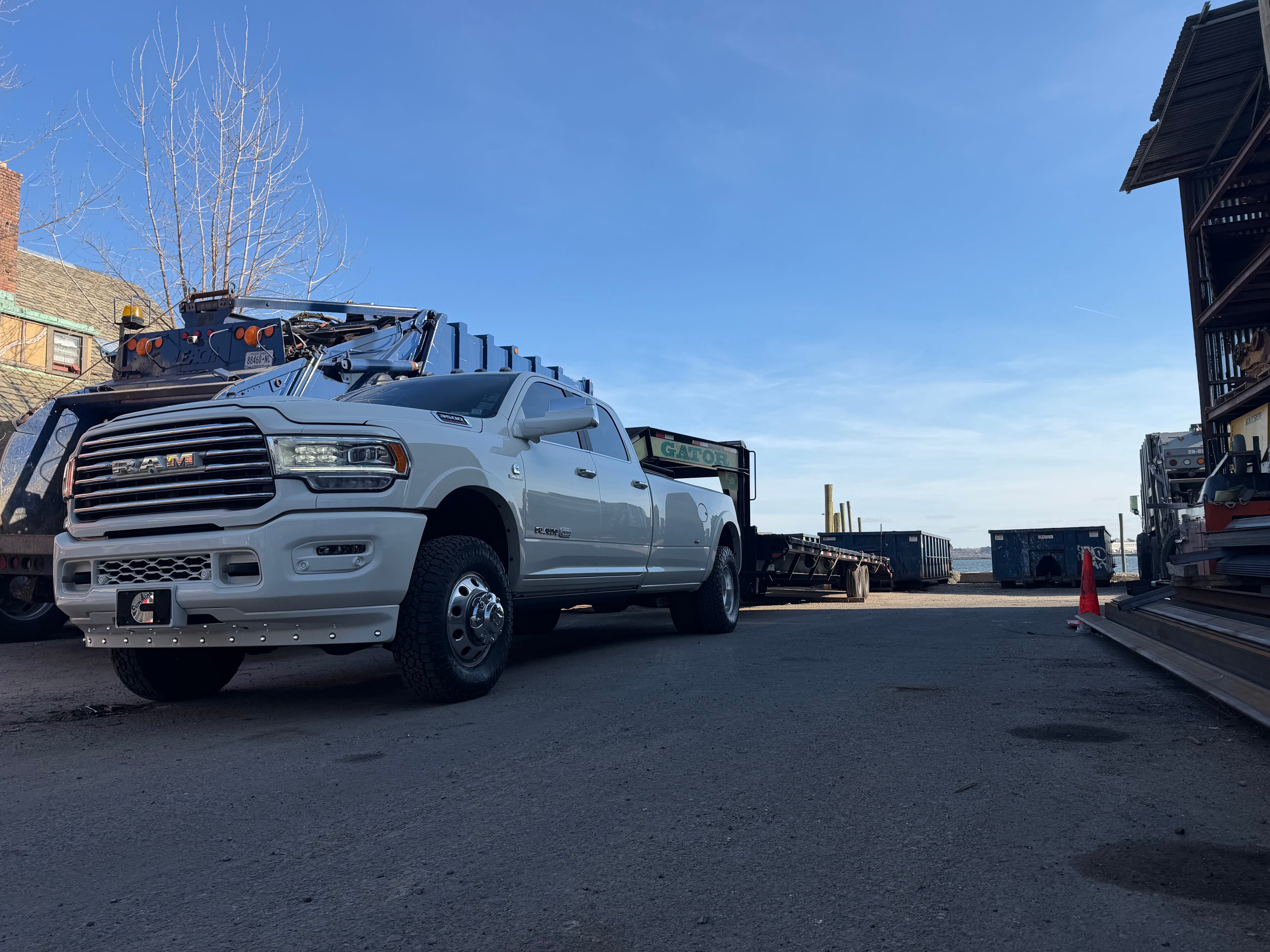 White heavy-duty pickup truck in an industrial yard.